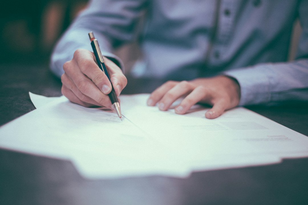 Signing property transfer documents at a desk